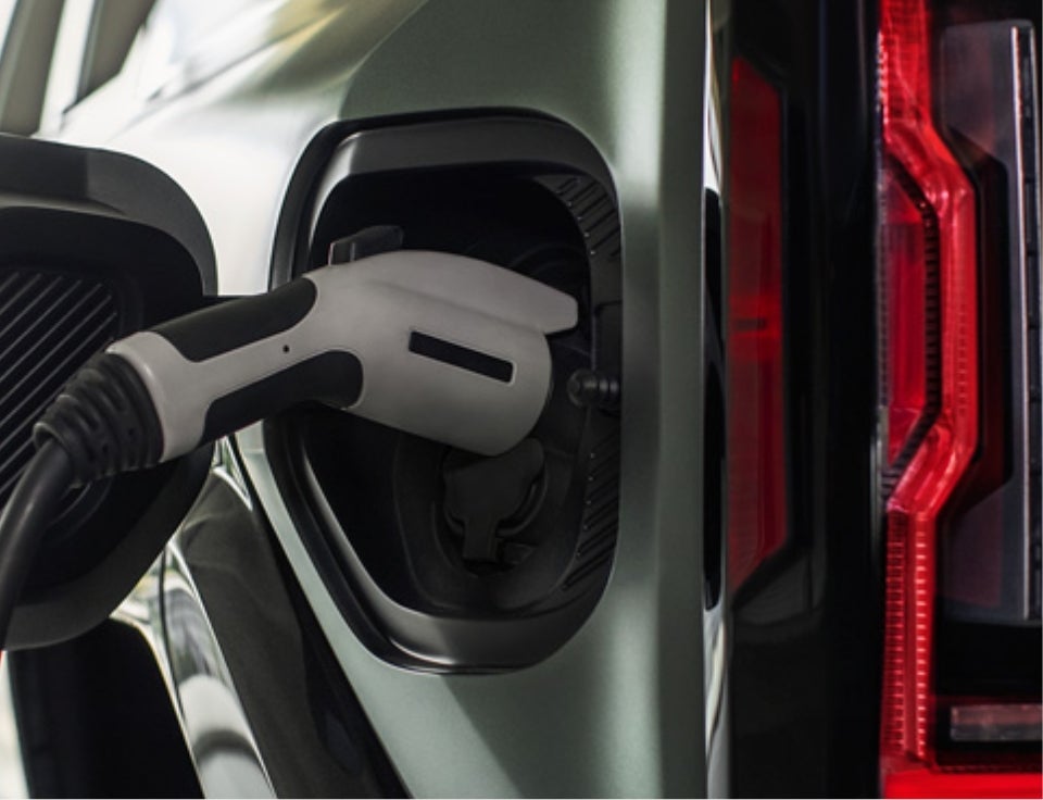 Close up of charging port with charger plugged in on a GMC Hummer EV SUV - Courtesy GMC in BIRMINGHAM AL